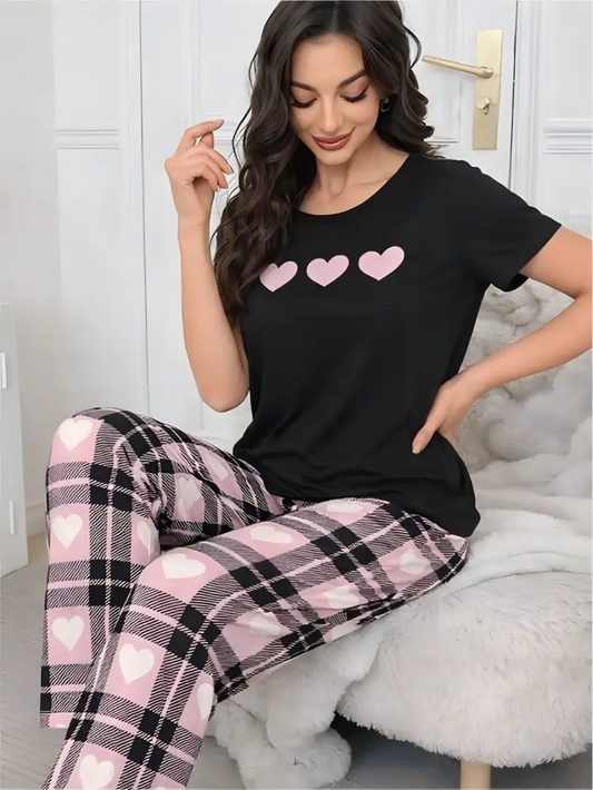 Pijama larga para mujer, camiseta negra con tres corazones rosas y pantalón largo a cuadros rosas con corazones blancos.