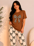 Pijama larga para mujer, camiseta café con moño animal print y pantalón claro con estampado de moños.